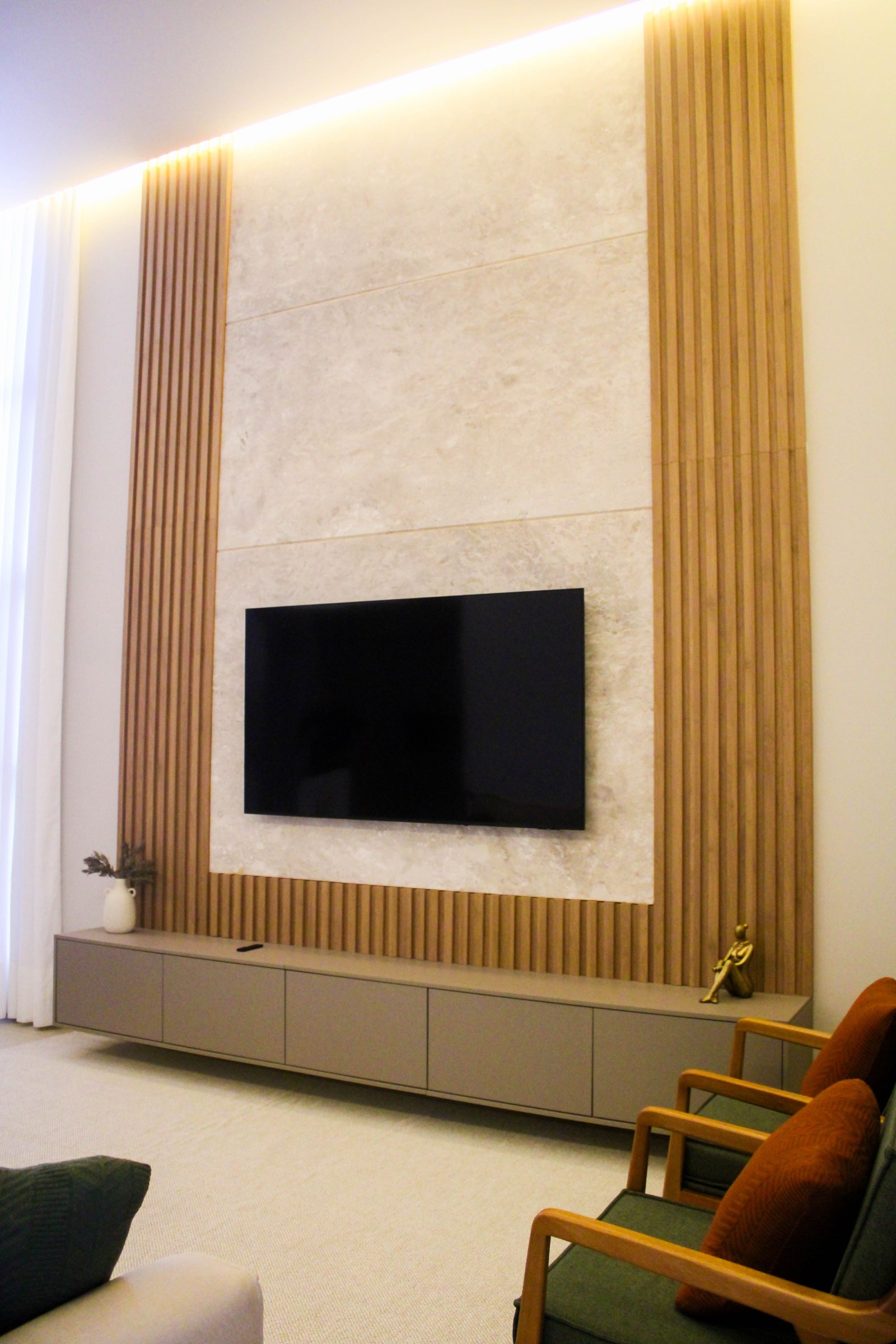 Sala de estar com painel ripado e pé-direito alto